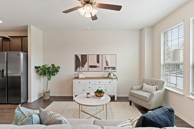 living room featuring ceiling fan, dark wood-type flooring, and a wealth of natural light