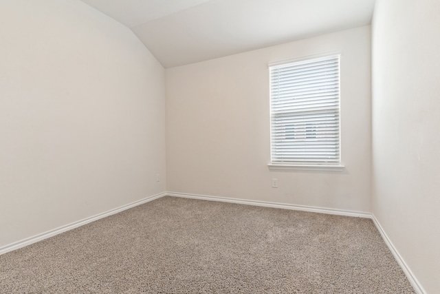 spare room featuring lofted ceiling and carpet