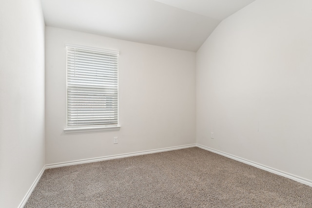 unfurnished room featuring lofted ceiling, a healthy amount of sunlight, and carpet