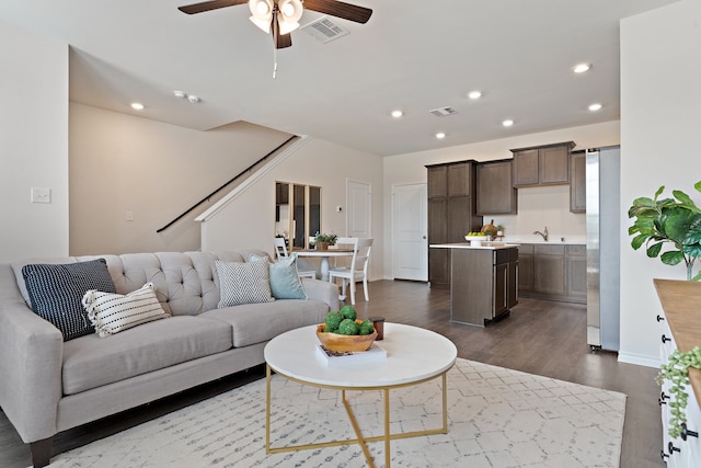 living room with dark wood-type flooring and ceiling fan