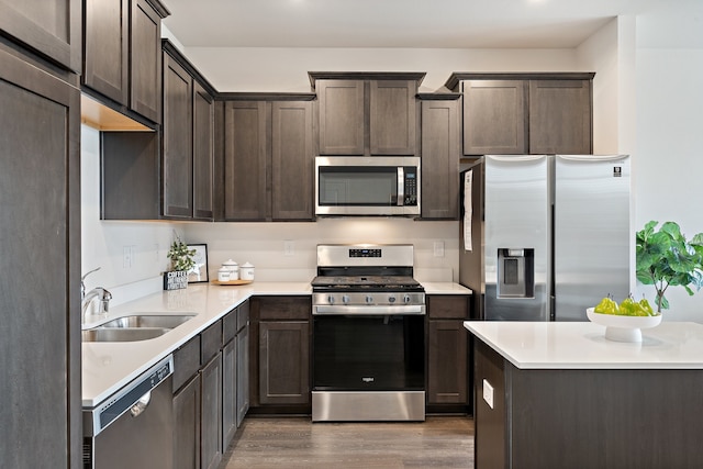 kitchen featuring sink, dark brown cabinets, stainless steel appliances, and wood-type flooring