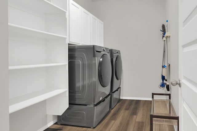 clothes washing area with cabinets, independent washer and dryer, and dark hardwood / wood-style flooring