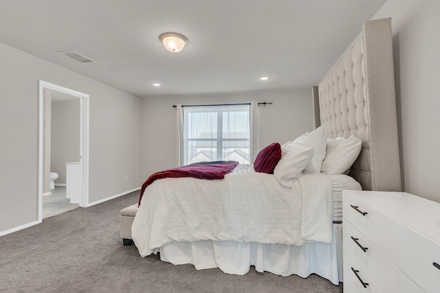 bedroom featuring dark colored carpet and connected bathroom