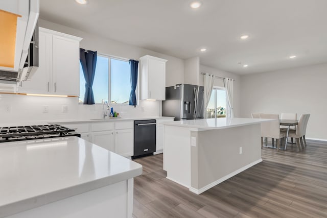 kitchen featuring white cabinets, a kitchen island, sink, and stainless steel appliances