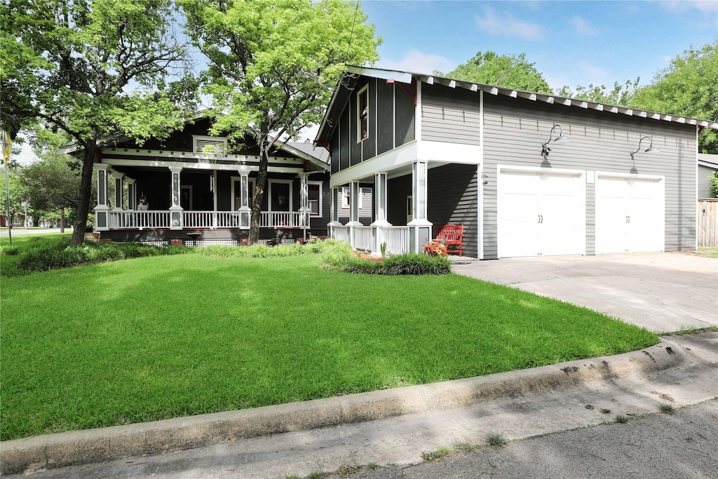 view of front facade featuring a garage, covered porch, and a front yard