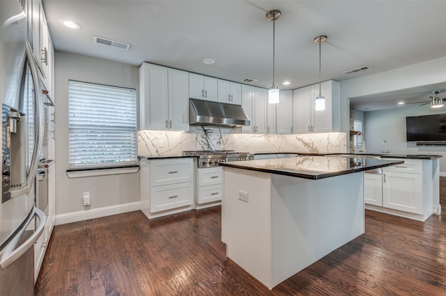 kitchen with dark wood-type flooring, white cabinets, decorative light fixtures, and tasteful backsplash