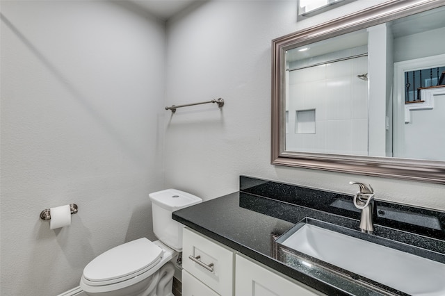 bathroom with vanity, toilet, and a shower