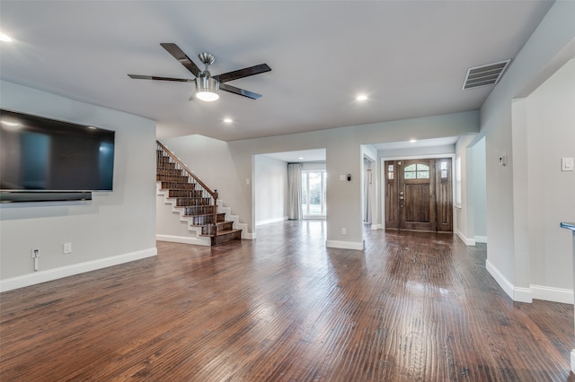 unfurnished living room featuring dark wood-type flooring and ceiling fan