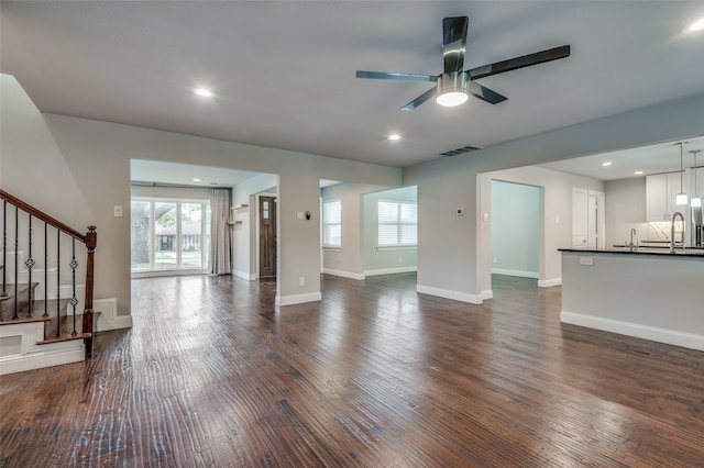 unfurnished living room with ceiling fan, sink, and dark hardwood / wood-style flooring