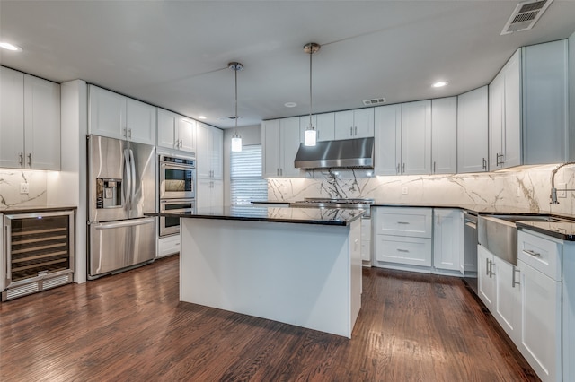 kitchen with wine cooler, white cabinetry, stainless steel appliances, and extractor fan