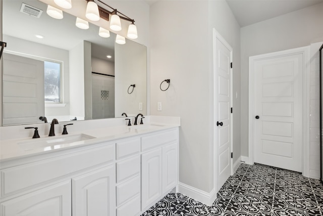 bathroom with tile patterned floors, a shower with door, and vanity