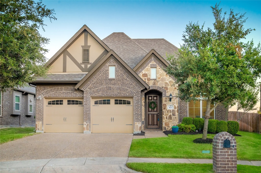 tudor house with a front yard and a garage