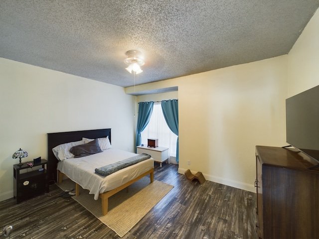 bedroom with a textured ceiling, ceiling fan, and dark wood-type flooring