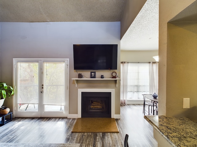 9747 Whitehurst Dr Unit 146, Dallas, TX 75243 - living area featuring wood finished floors, a fireplace, and a textured ceiling