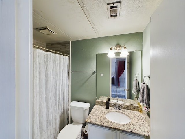 bathroom with toilet, vanity, and a textured ceiling