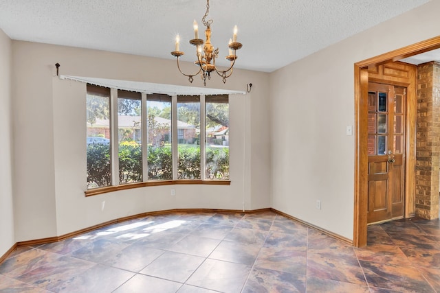 spare room with a textured ceiling and a chandelier