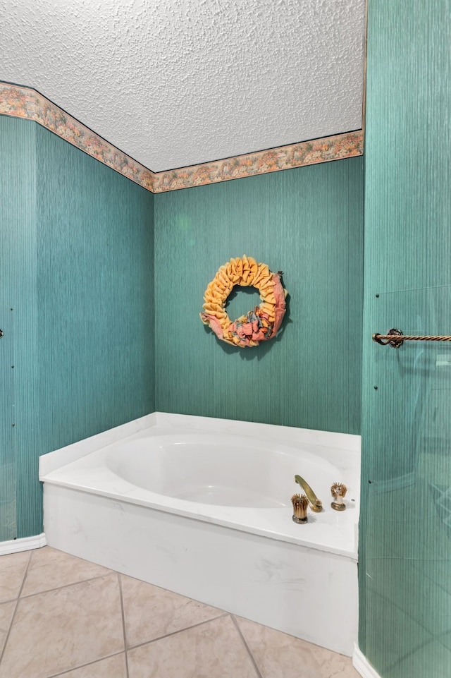 bathroom featuring a bath, tile patterned floors, and a textured ceiling