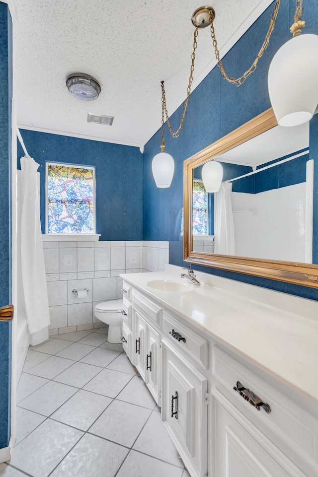 bathroom with vanity, a textured ceiling, toilet, and plenty of natural light