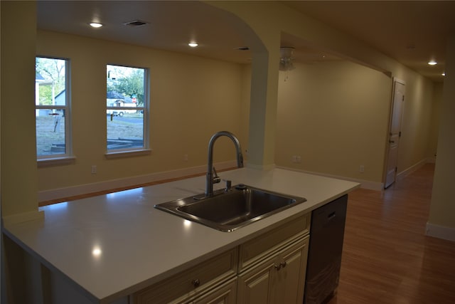 kitchen with sink, an island with sink, dishwasher, hardwood / wood-style floors, and ceiling fan