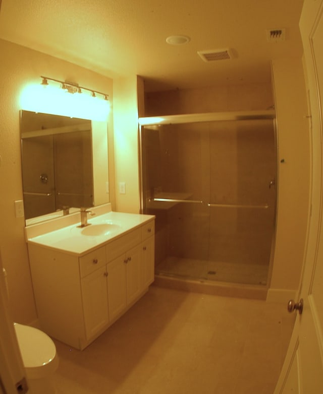 bathroom featuring vanity, an enclosed shower, and toilet