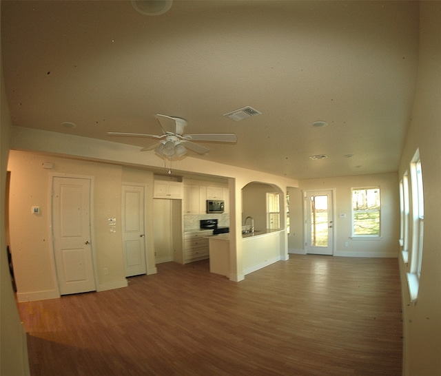 unfurnished living room with sink, wood-type flooring, and ceiling fan