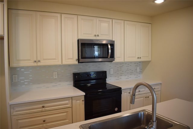 621 E Murray St, Denison, TX 75021 - kitchen with tasteful backsplash, stainless steel microwave, light countertops, a sink, and black electric range oven
