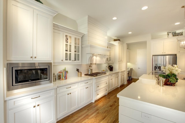 3124 Shaddock Blvd, Rockwall, TX 75032 - kitchen with recessed lighting, stainless steel appliances, white cabinets, a sink, and light wood-type flooring