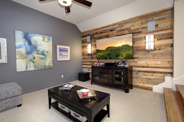 living room featuring vaulted ceiling, ceiling fan, carpet floors, and wood walls