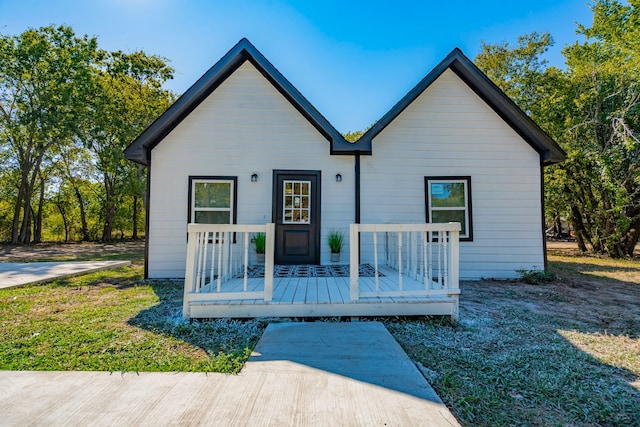 bungalow with a wooden deck and a front lawn