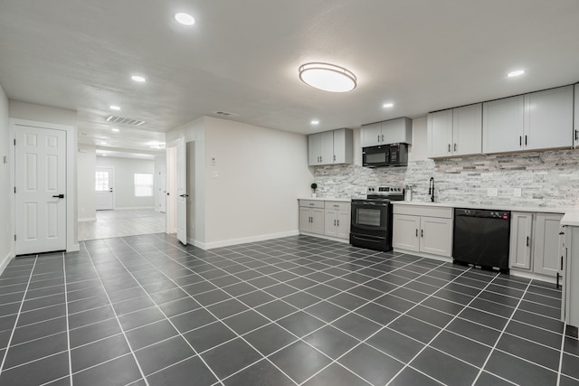 kitchen with black appliances, white cabinets, tasteful backsplash, and dark tile patterned flooring