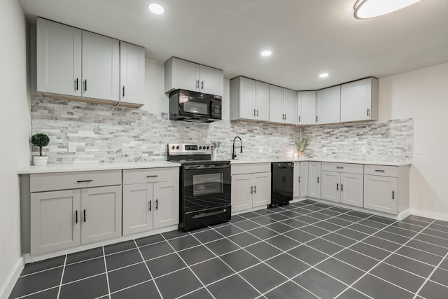 kitchen with sink, black appliances, white cabinets, and tasteful backsplash