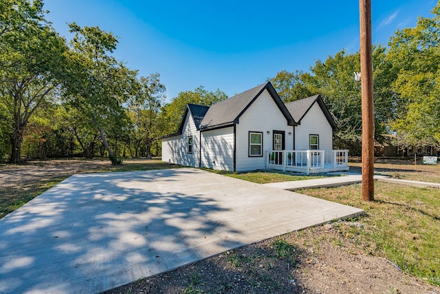 view of side of property featuring a lawn and a porch