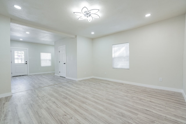 empty room featuring light hardwood / wood-style floors and a textured ceiling