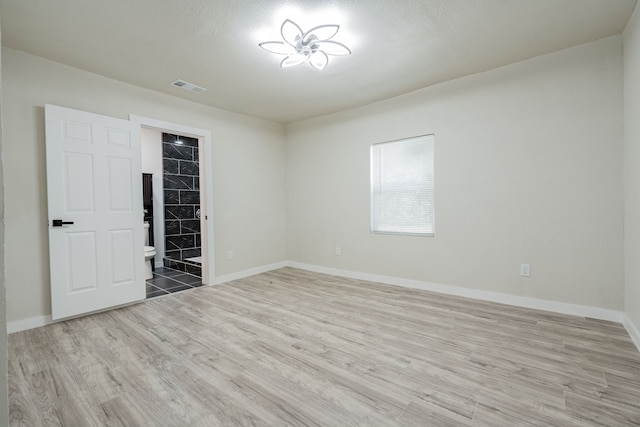 empty room featuring a textured ceiling and light wood-type flooring