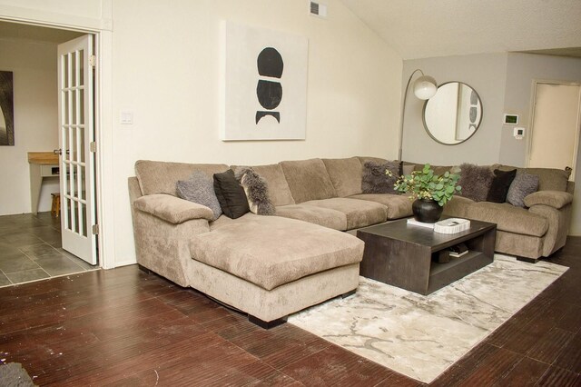 living room featuring ceiling fan, vaulted ceiling, a brick fireplace, and dark hardwood / wood-style flooring