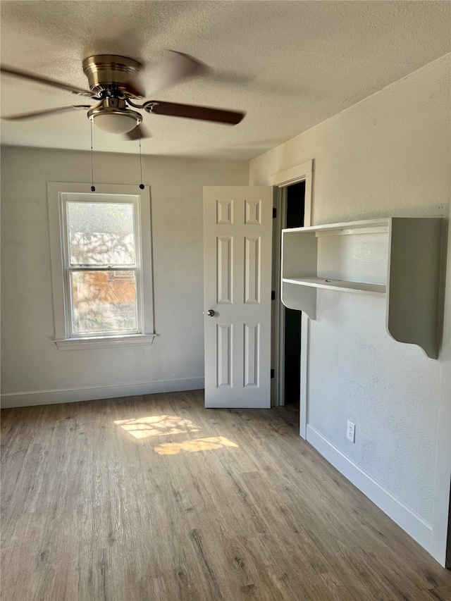 unfurnished bedroom featuring a textured ceiling, light hardwood / wood-style floors, and ceiling fan