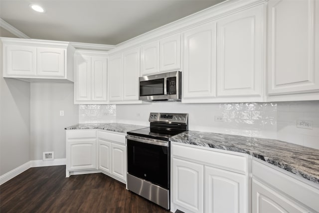 kitchen featuring dark wood-type flooring, white cabinets, ornamental molding, tasteful backsplash, and stainless steel appliances