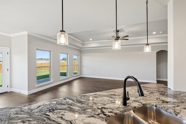 kitchen with pendant lighting, sink, ceiling fan, ornamental molding, and dark hardwood / wood-style flooring