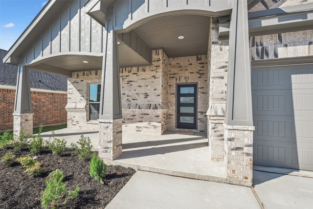 view of exterior entry featuring covered porch and a garage