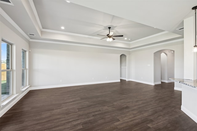 unfurnished room with dark hardwood / wood-style floors, crown molding, ceiling fan, and a tray ceiling