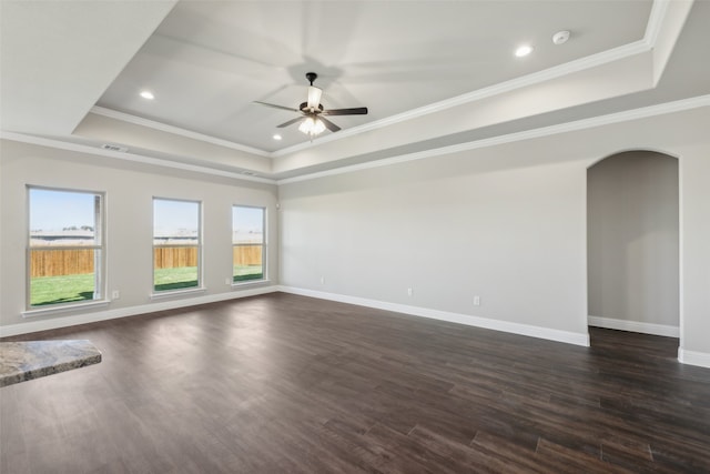 spare room with ornamental molding, dark wood-type flooring, and a tray ceiling