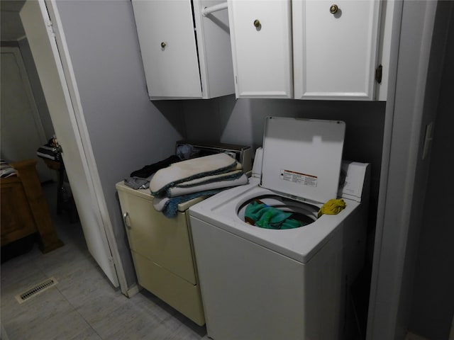 clothes washing area with cabinets and washer / clothes dryer