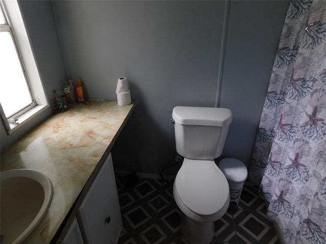 bathroom with vanity, curtained shower, and toilet