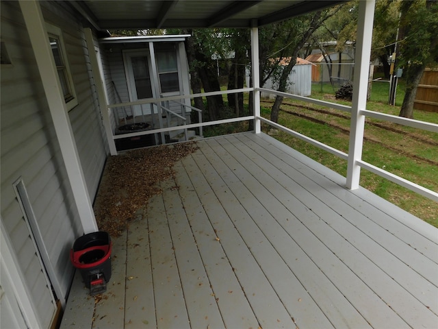 wooden terrace featuring a yard and a storage shed