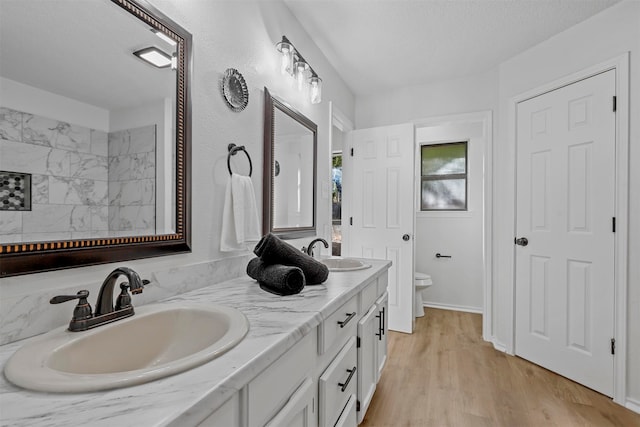 bathroom with hardwood / wood-style flooring, vanity, a textured ceiling, and toilet