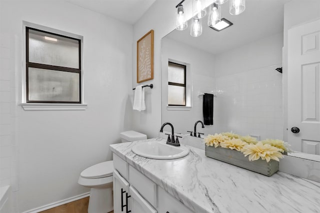 bathroom with vanity, toilet, and a shower