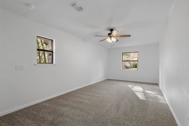 empty room featuring carpet flooring, ceiling fan, and a healthy amount of sunlight