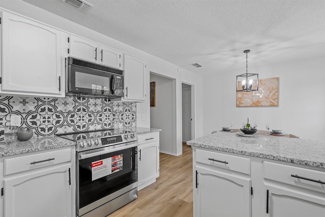 kitchen featuring light wood-type flooring, tasteful backsplash, white cabinetry, and stainless steel range oven