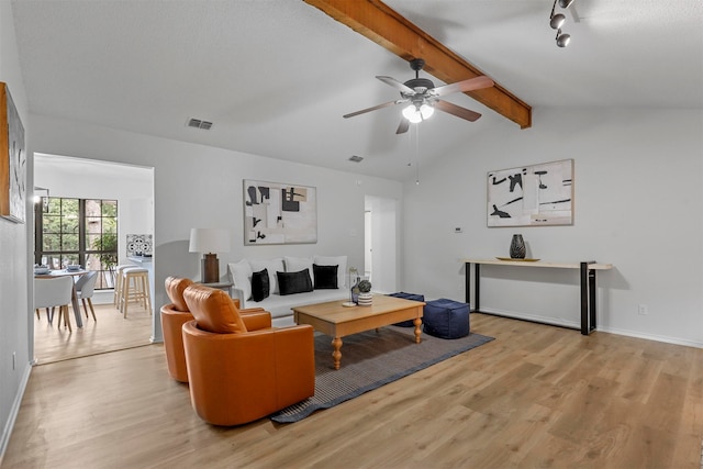 living room featuring vaulted ceiling with beams, ceiling fan, and light hardwood / wood-style flooring