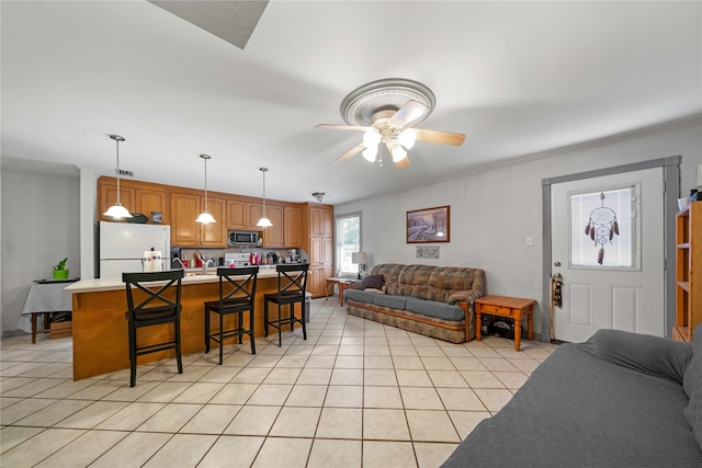 living room with ceiling fan, crown molding, and light tile patterned flooring